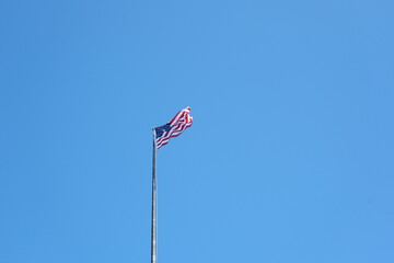 American flag waving with clear sky in background