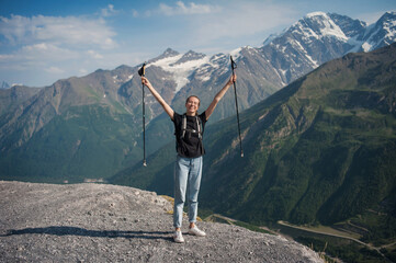 Happy tourist girl against the backdrop of a beautiful mountain landscape