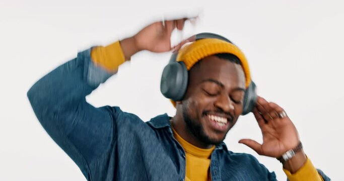 Music headphones, dancing or happy black man streaming in studio for freedom on white background. Smile, excited or African person listening to a radio song, sound or audio on an online subscription