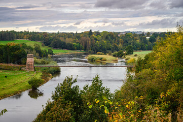 Elevated View of the Union Chain Bridge, a suspension road bridge that spans the River Tweed between England and Scotland located four miles upstream of Berwick Upon Tweed