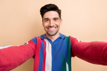 Self portrait of cheerful toothy smiling businessman showing his lifestyle blog recording video...