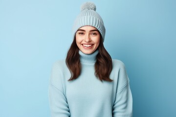 Cheerful young woman in winter outfit looking at camera and smiling.
