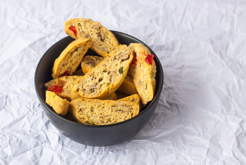 Homemade biscotti or cantuccini. Sweet gluten-free dessert in a black ceramic cup.
