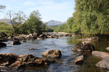 A peaceful river leading to a hill in the Scottish Highlands