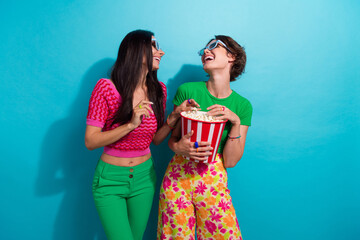 Photo of two friends girls youngsters joking positive eat popcorn entertain each other cinema...