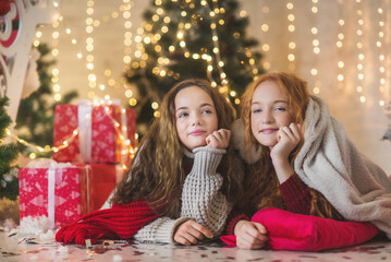 Two teenagers girls in christmas decorations. New year lights garlands. Christmas card with two pretty girls