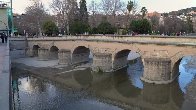 The Roman Bridge, an old arch bridge spanning the Genil river in central Granada, region of Andalusia, Spain