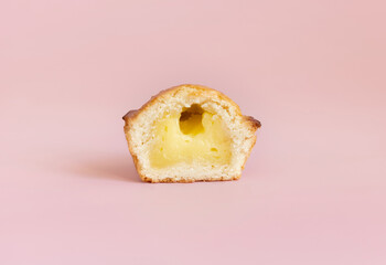 Pasticciotto leccese pastry filled with egg custard cream on a light pink, close up