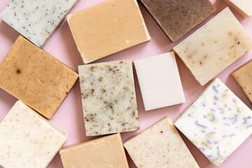 Beige and brown handmade soap bars on light pink top view. Natural herbal product for SPA