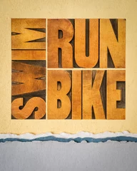 Schilderijen op glas run, bike, swim - triathlon concept,  word abstract in vintage letterpress wood type on art paper, sport and recreation concept © MarekPhotoDesign.com