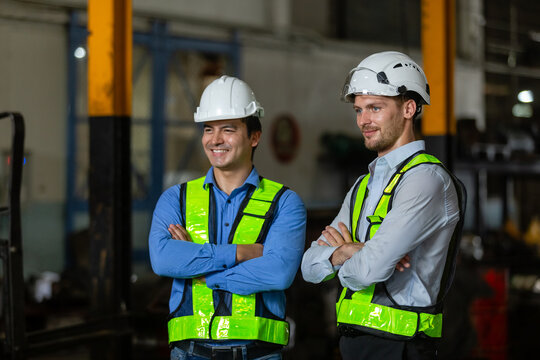 Portrait team engineer train arms crossed standing at train diesel engine in maintenance center. Team railway engineer Inspect repair project train diesel.