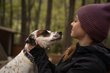Outside a Glamping , The girl wearing a woolen cap plays with her dog in the middle of nature...