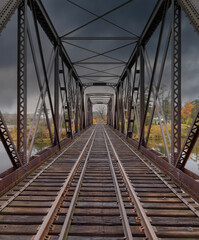 Double span riveted railway truss bridge built in 1893 crossing the Mississippi river in autumn in...