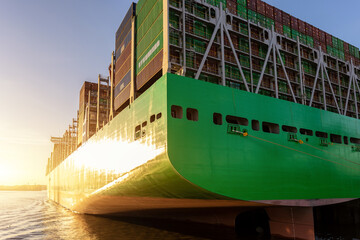Scenic view giant cargo container ship loading Hamburg city port harbour against seaport cranes...
