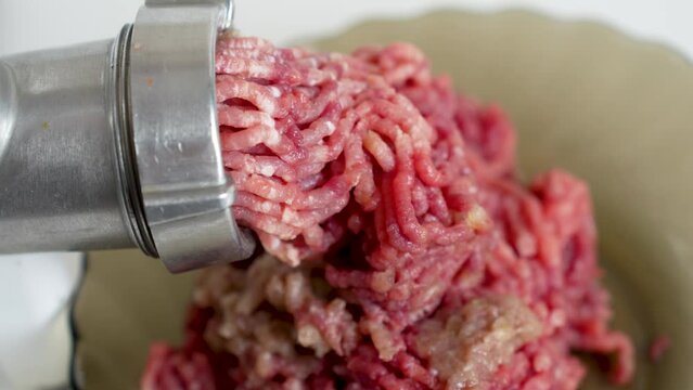 Beef mince in a mincing machine, close up.