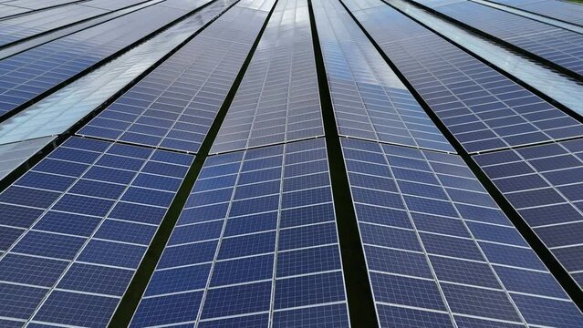 Solar panel park aerial flying low over the panels, nothing else in sight
