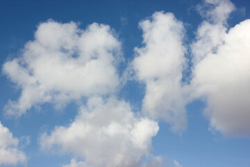 A clear blue sky with soft, billowing layers of white clouds is a symbol of good weather