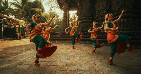 Dynamic Shot of Indian Women in Traditional Clothes Dancing Bharatanatyam in Colourful Sari While Looking at the Camera. Young Females Sharing Folk Dance and Their South Asian Culture