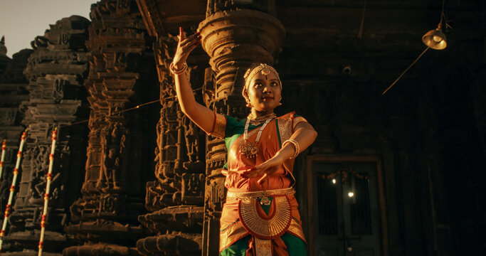 Energetic Indian Woman Showcases the Graceful Movement of Her Legs in Traditional Attire while Dancing Bharatanatyam. Female Dancer Enjoying the Spectacular South Asian Folk Dance in an Ancient Temple