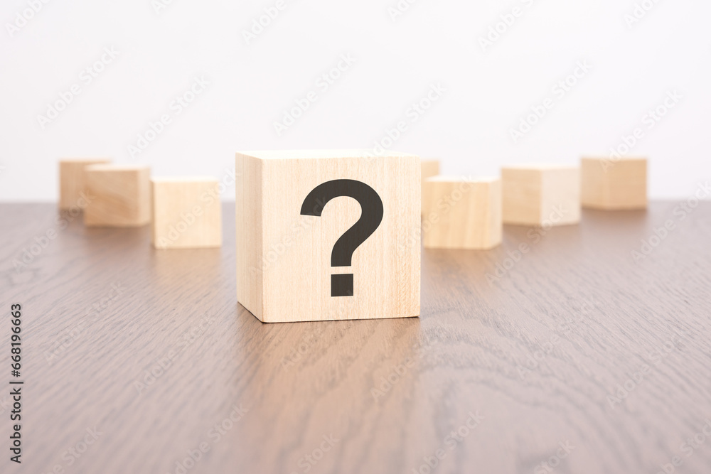 Poster question marks blocks stand on wooden background with copy space