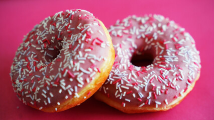 donuts with icing and powder on a pink background