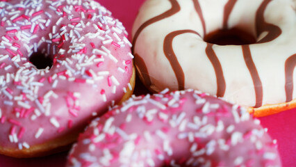 donuts with icing and powder on a pink background