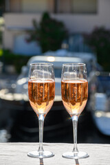 Summer party, drinking of French brut rose champagne sparkling wine in glasses in yacht harbour of Port Grimaud near Saint-Tropez, French Riviera vacation, France