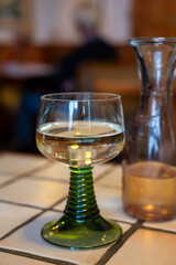 White quality riesling wine served in green swirl wine glass in old German restaurant in Monschau...