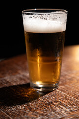 Pint glass of cold fresh british ale and lager beer served in old vintage English pub