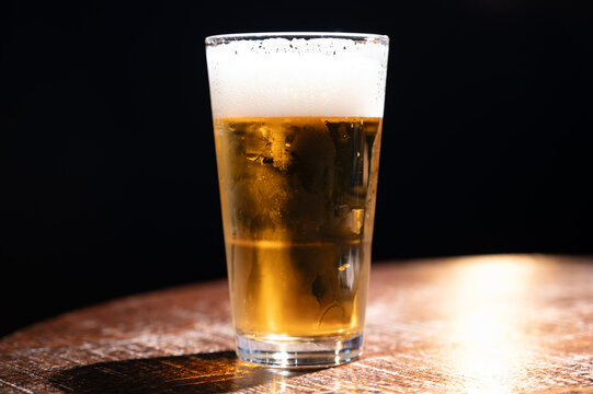 Pint Glass Of Cold Fresh British Ale And Lager Beer Served In Old Vintage English Pub