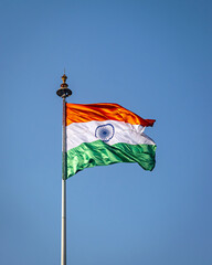 Indian National Flag , flying high in the sky on a beautiful , clear blue sky background.
