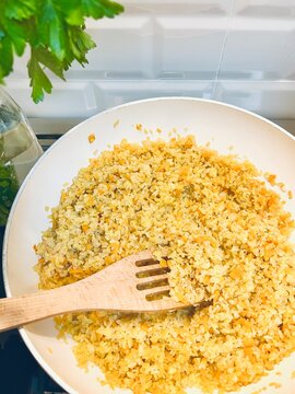 Overhead view a frying pan with white onion and bulgur wheat