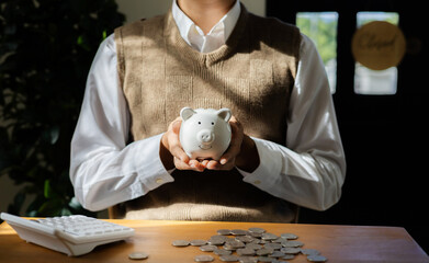Young man holds a piggy bank in his hand. Investment, retirement