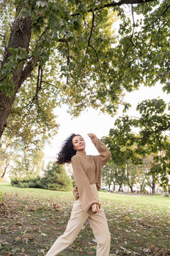 Portrait of a beautiful woman messing about in a park on a sunny autumn day, Belarus
