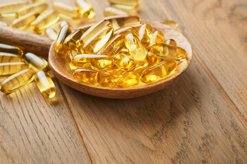 Close up capsules with Vitamin D, E or Omega 3,6,9 fatty acids in bottle on old wooden backgrounds. Food supplement oil filled fish oil. Natural supplements for healthy good life concept. Banner.