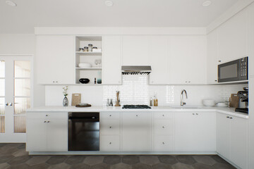 White kitchen with accent dishwasher and kitchen utensils. 