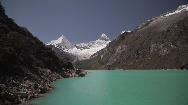 beautiful turquoise water of the lake at laguna paron lagoon in the high andes mountains of the cordillera blanca at huascaran, Peru, with snow covered mountain peaks on a bright sunny day.
