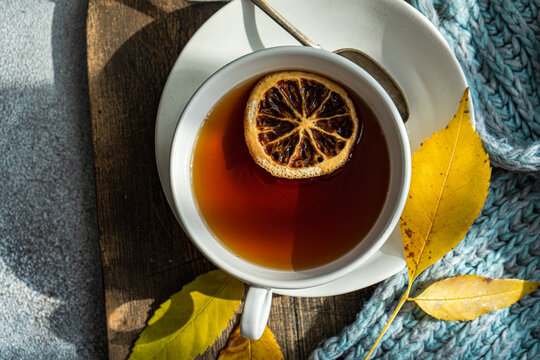 Overhead view of a cup of spiced black tea with lemon and autumnal styling