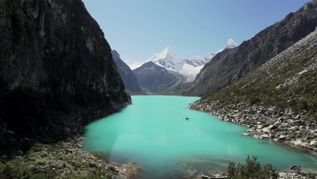beautiful turquoise water of the lake at laguna paron lagoon in the high andes mountains of the cordillera blanca at huascaran, Peru, with snow covered mountain peaks on a bright sunny day.