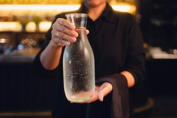 Kellnerin serviert Wasser im Restaurant