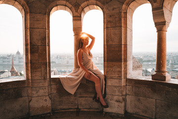 Young Woman in dress at sunrise with the city in the background in Budapest at the Fisherman's...