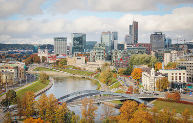 Vilnius, capital of Lithuania, Europe. Aerial view of the city, modern business financial district, modern architecture, buildings and skyscrapers, with Neris river and bridge in autumn