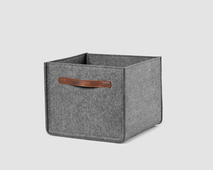 Functional storage box of gray felt with brown leather handles