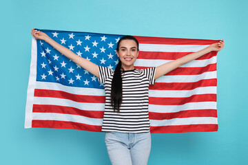 4th of July - Independence Day of USA. Happy woman with American flag on light blue background