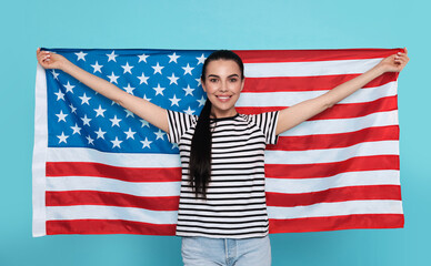 4th of July - Independence Day of USA. Happy woman with American flag on light blue background