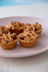 Apple pie on a pink plate on a white background