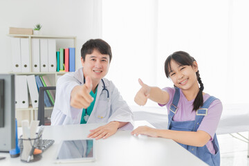 Fototapeta premium asian doctor and children patient show thumb up sign with hands together, happiness and relationship in hospital, they feeling happy and smile