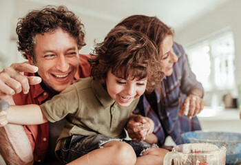 Joyful family having fun while baking together in the kitchen