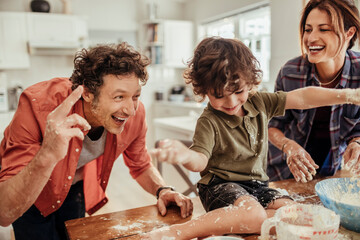 Joyful family having fun while baking together in the kitchen