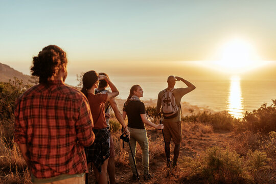Group of Friends Admiring Sunset After a Coastal Hike